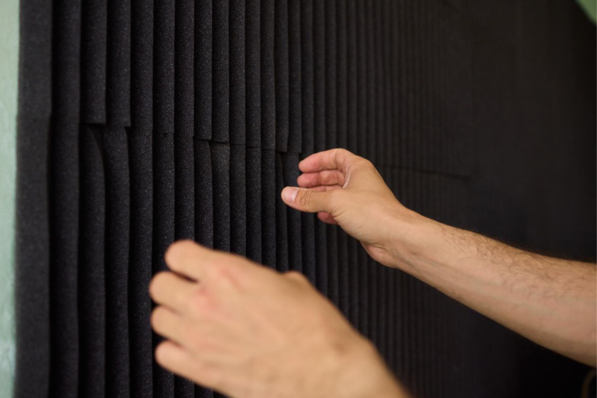 Un hombre instala aislamiento ac&uacute;stico para hosteleria