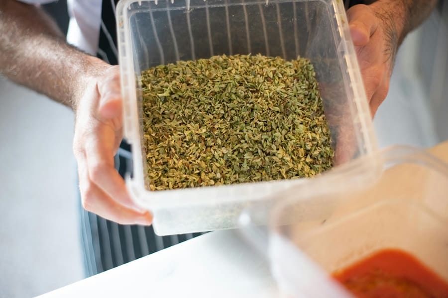 Las manos de un hombre sostienen un tupper con ingredientes en el interior