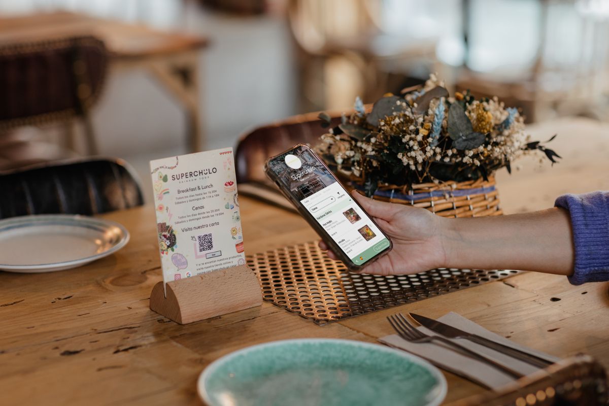 Una clienta consulta una carta a trav&eacute;s de un c&oacute;digo QR